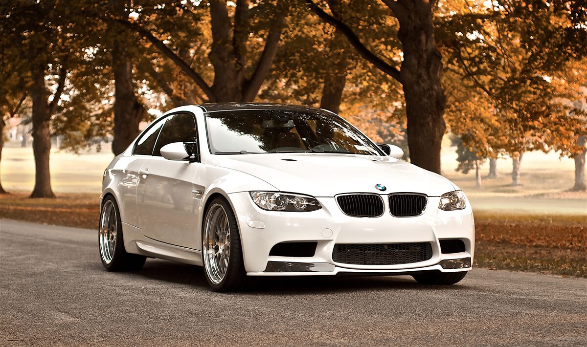 Fototapet un bmw alb conduce pe șosea în toamnă