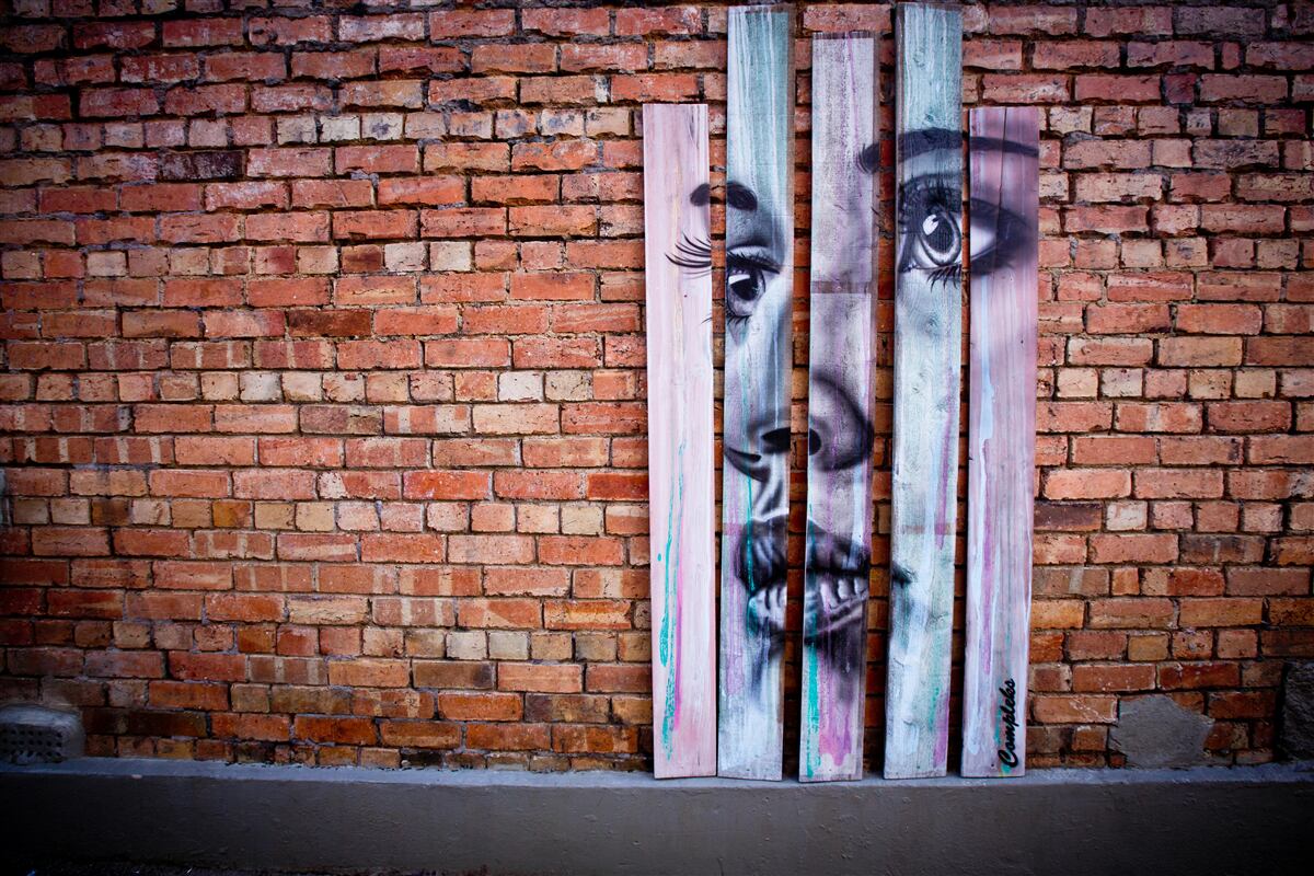 Fototapet imaginea unei femei pe un zid de cărămidă stacojiu